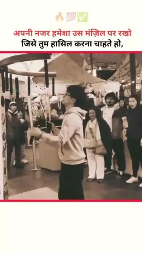 Young man with curly hair in a hoodie plays a ball-kicking game in a market, sepia tone.