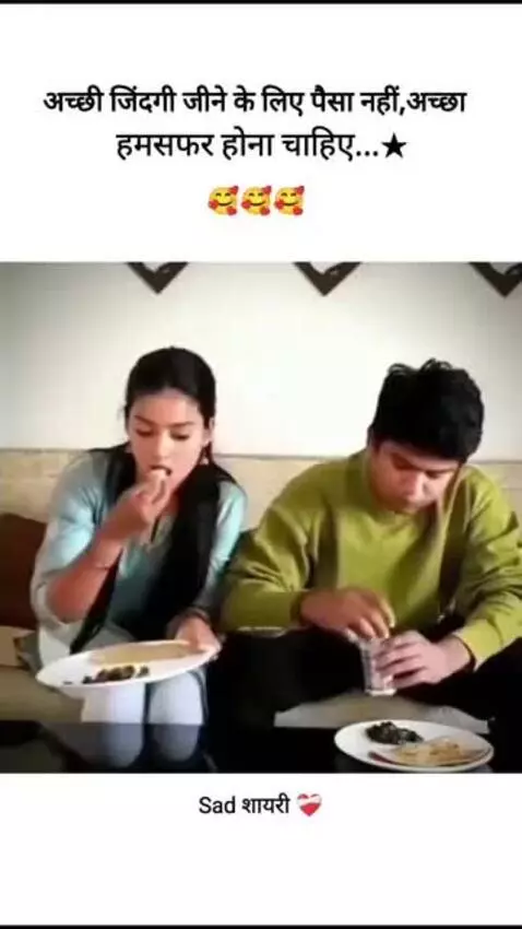 Couple sitting on a couch, sharing a meal, with the woman feeding the man and showing affection.