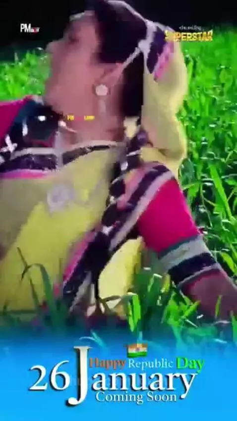 Couple in traditional Indian clothing dancing outdoors with a lush green background, celebrating Republic Day.