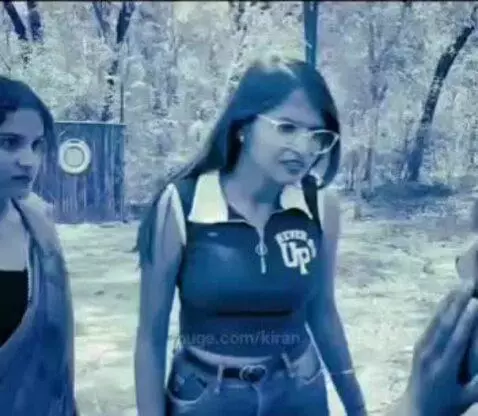 Man in a park being argued with and hit by two women, one in blue and one in a saree.