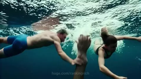 Couple pulled down by a giant hand underwater, surrounded by colorful fish.