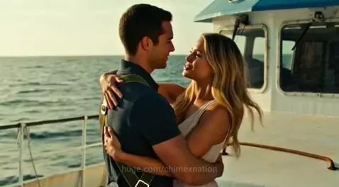 Man parachuting from helicopter onto a boat to embrace a waiting woman.