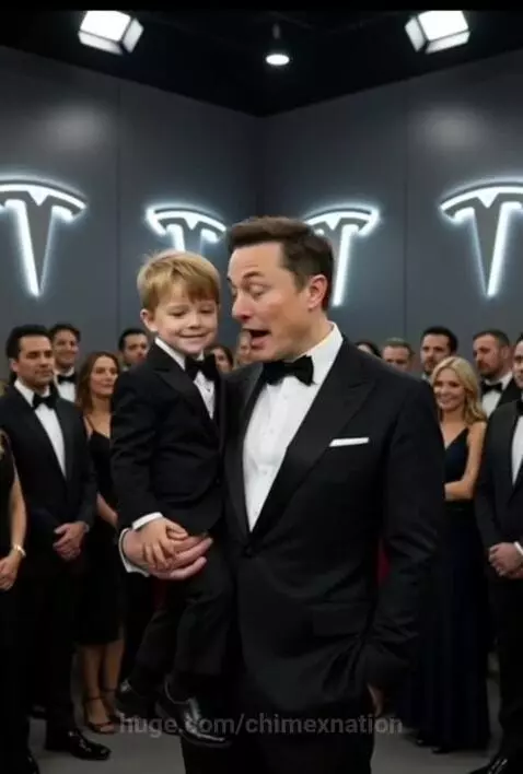 Elon Musk in a tuxedo holding a young boy in a tuxedo, with illuminated Tesla logos on the wall.