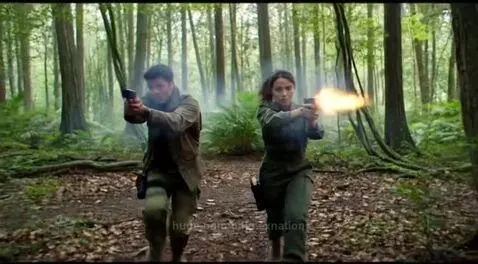 Two individuals in tactical clothing running and firing handguns in a dense forest, with muzzle flashes and smoke.