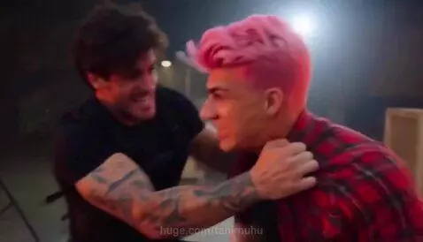 Man with pink hair being slammed through a shattering glass window during a fight.