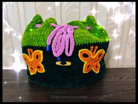 Montage of colorful crocheted items including animal backpacks, bags, baskets, and clothing, with a woman and children interacting with them.