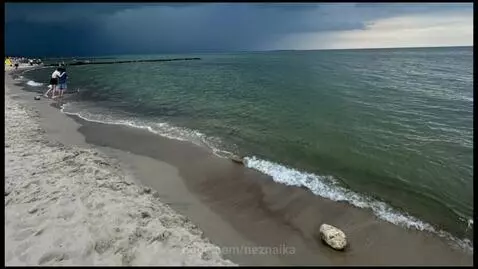 Aerial view of Kaliningrad cityscape with a bridge and historical buildings, transitioning to the Curonian Spit dunes.