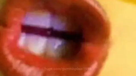 Animated yellow face with realistic eyes and pixelated sunglasses rapping in front of a colorful, swirling background.