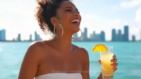 Young adults celebrating on a luxury yacht in Miami with city skyline and turquoise water backdrop.