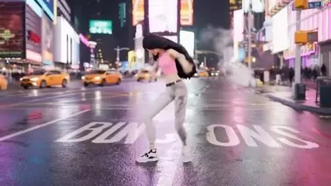 Animated woman with dark hair dancing energetically on a wet street in Times Square at night, surrounded by bright billboards and taxis.