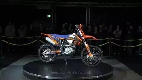 A vibrant orange, blue, and white JHL Z5 dirt bike displayed on a rotating platform.
