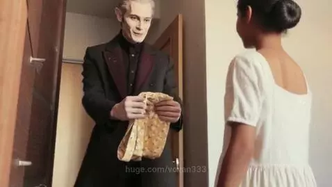 Man in black suit hands a woman in white a yellow floral sundress, a thoughtful summer gift.