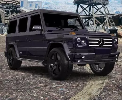 Dark Mercedes G-Class SUV with black rims parked on a dirt road, desert landscape in background.