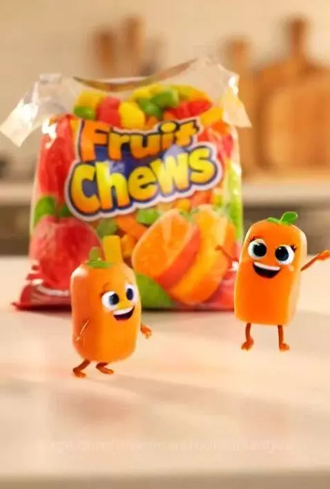 Animated fruit chews with smiling faces popping out of a bag and dancing on a kitchen counter.