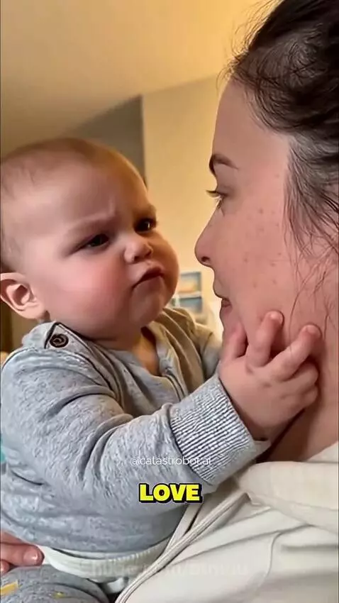 Baby holding mom's face, looking intently, demanding to be her only love.