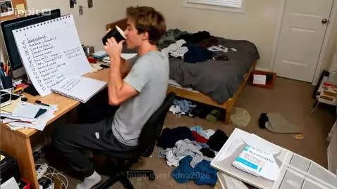 Man in a messy bedroom looking overwhelmed, holding a to-do list and coffee.