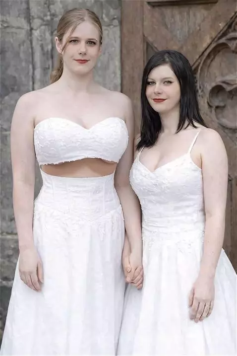 Woman in a white dress with a visual effect making her breasts appear larger.