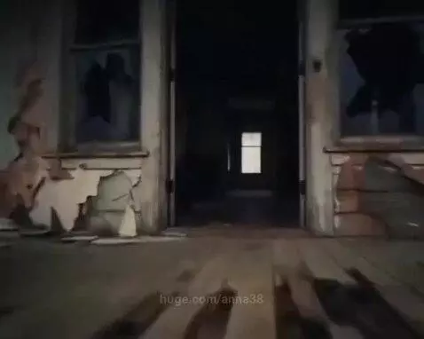 Exterior of a decaying abandoned house under a dark sky, with a ghost figure appearing in a window.
