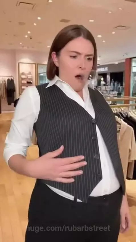 Woman in vest and pants with rapidly expanding, bubbly stomach and popping buttons, looking panicked.