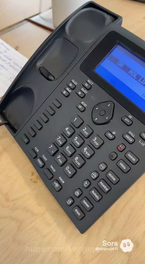 Man on phone makes coworkers laugh with a funny comment, office environment.