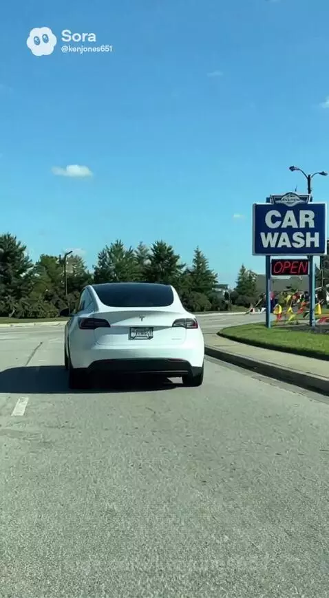 Man in white shirt looking annoyed as his white Tesla drives into a car wash.