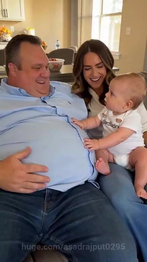 Baby playfully interacts with a man's belly, asking about his "baby".