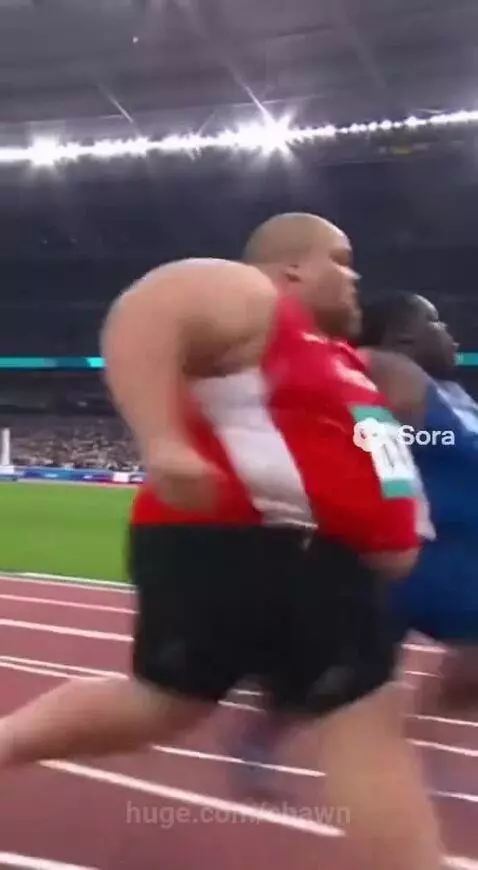 Male track and field athletes sprinting during a race, one athlete falls to the ground.