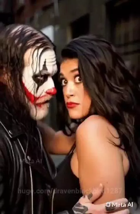Man with clown makeup and woman in leather embrace closely in an urban setting with glowing effects.