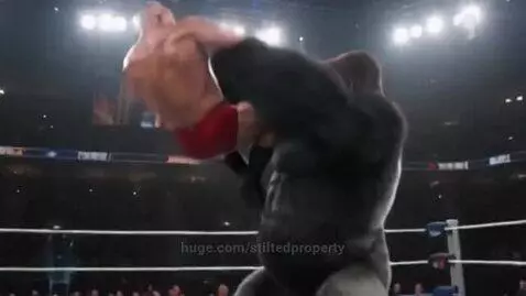 A muscular bald wrestler in red trunks is on the ground while a large, dark-furred gorilla stands over him, beating its chest.