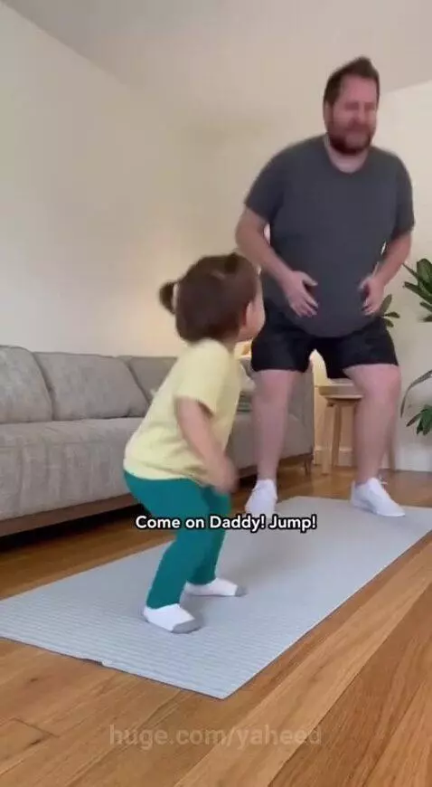 Father and young daughter exercising on a yoga mat, daughter playfully directing father's movements.