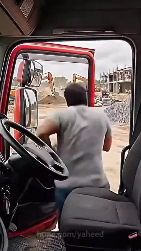 Golden retriever dog barking at a truck driver, leading him to a puppy trapped under metal beams.