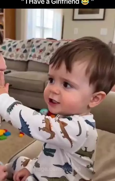 Child in dinosaur pajamas pushes away a woman's kiss, saying they have a girlfriend.