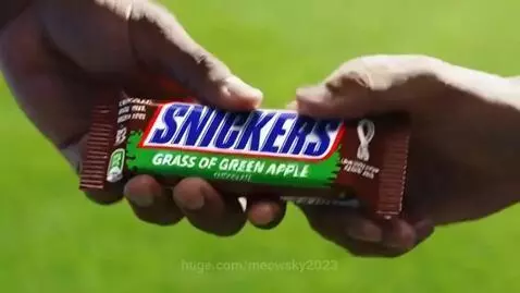 Soccer player happily dribbling a ball after eating a green Snickers bar.