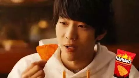 Man dramatically breathing fire and chips after eating a spicy Firemouth chip.