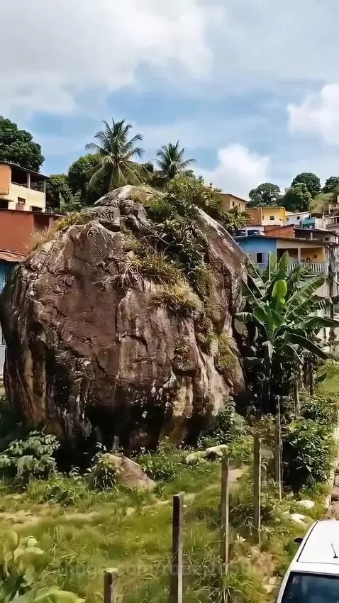 Stunning modern house built on and around a large rock formation, with an infinity pool on the rooftop.