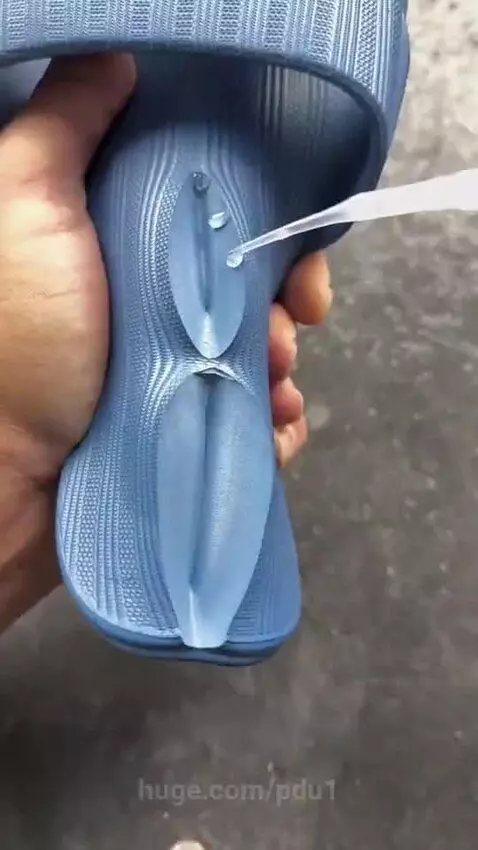 Close-up of a blue rubber slipper being repaired with a utility knife and liquid application.