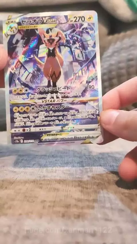 A holographic Japanese Zeraora VSTAR Pokémon trading card held up, showing its shiny front.
