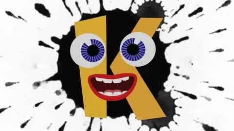 Animated yellow letter K with blue eyes and red mouth on a black ink splat background.