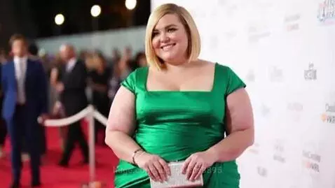Three female celebrities posing on a red carpet, smiling and embracing their bodies in stylish gowns and a suit.