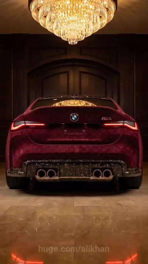 Custom BMW M4 Competition wrapped in burgundy velvet with gold accents, parked in an opulent showroom.