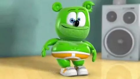 Animated green Gummy Bear character with blue eyes and a smile, wearing boxer briefs and sneakers, dancing.
